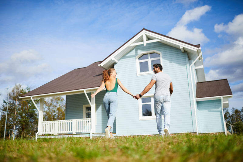 Canton MI homeowners walking to their house, protected by customized AAA insurance policies from Mark Ismail Insurance Agency.