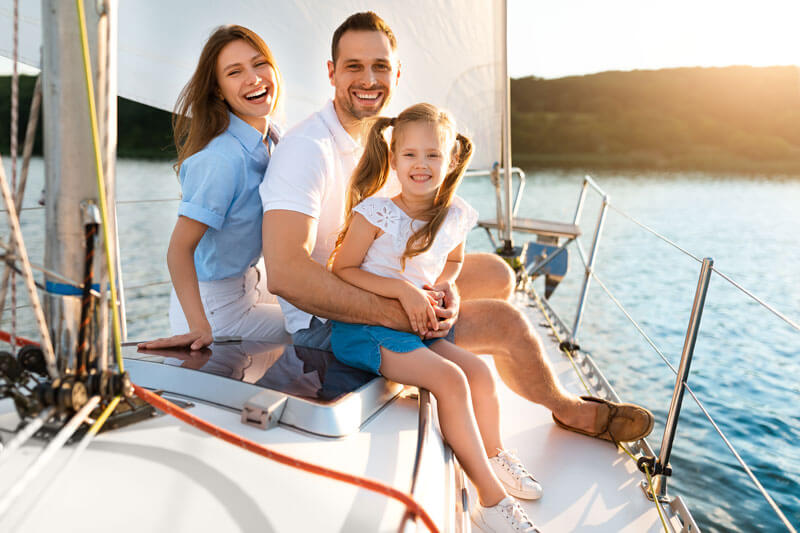 A happy family enjoying a sunny day on their boat in Dearborn Heights, protected by comprehensive boat insurance and life insurance.